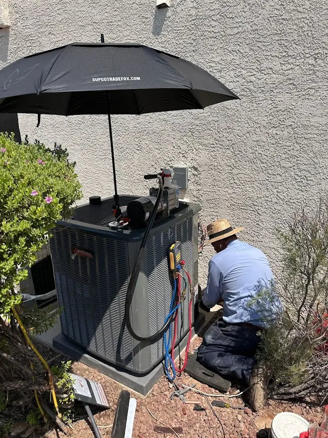 HVAC technician performing outdoor AC maintenance in Lower Salford